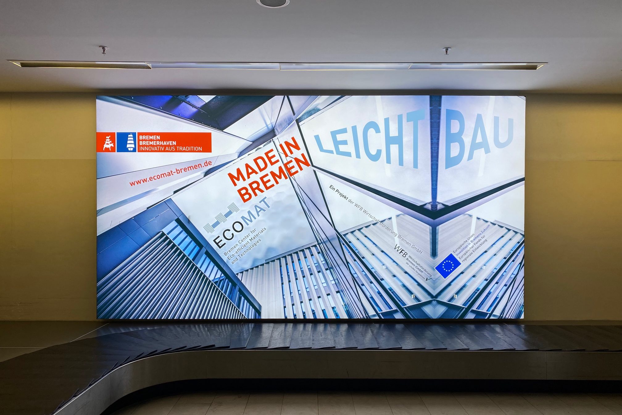 Flughafen Gebäckband mit einer Leuchtreklame der Wirtschaftsförderung Bremen GmbH zum Thema Leichtbau